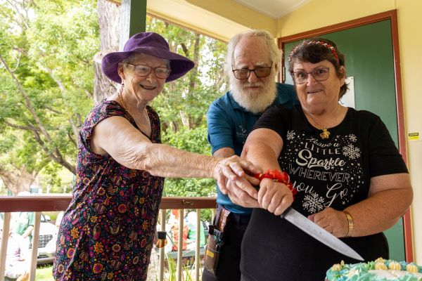 Somerset volunteers Sandy Wright, George Winter and Pauline Lawson cutting the cake at the Esk Visitor Information Centre to celebrate International Volunteers Day